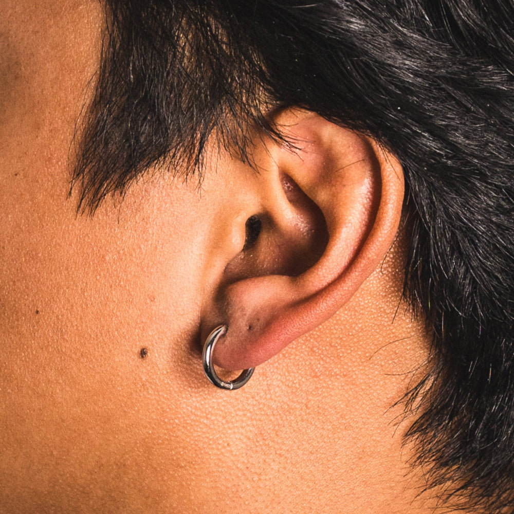 Close-up of an ear with a silver hoop earring