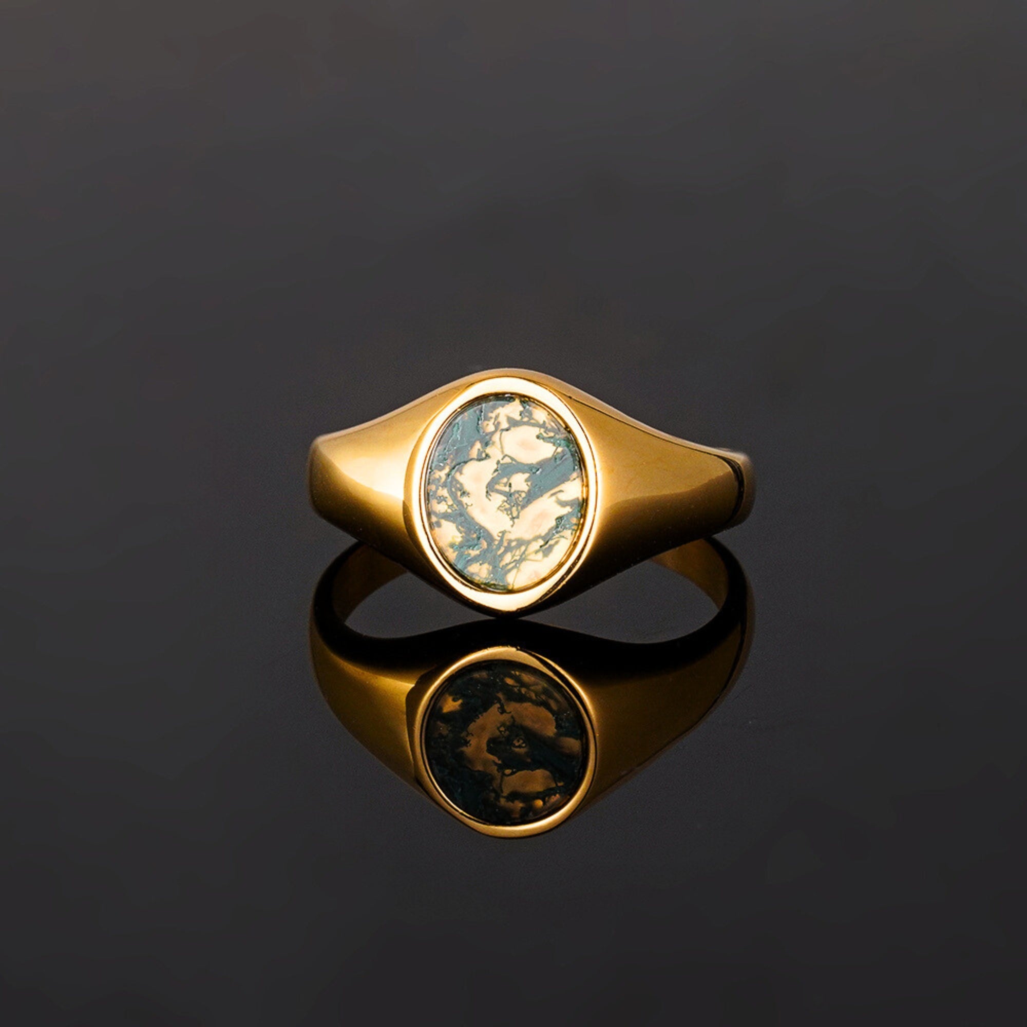 Gold ring with a circular design on a black background