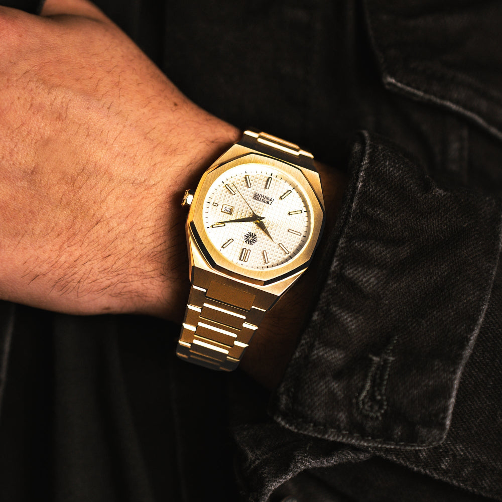 Gold wristwatch on a person's wrist with a dark background