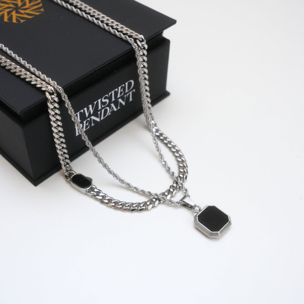 Silver chain necklace with black pendants on a 'Twisted Pendant' branded box.