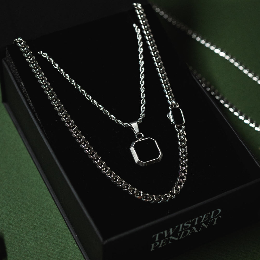 Silver necklace with a pendant on a black box labeled 'Twisted Pendant'.