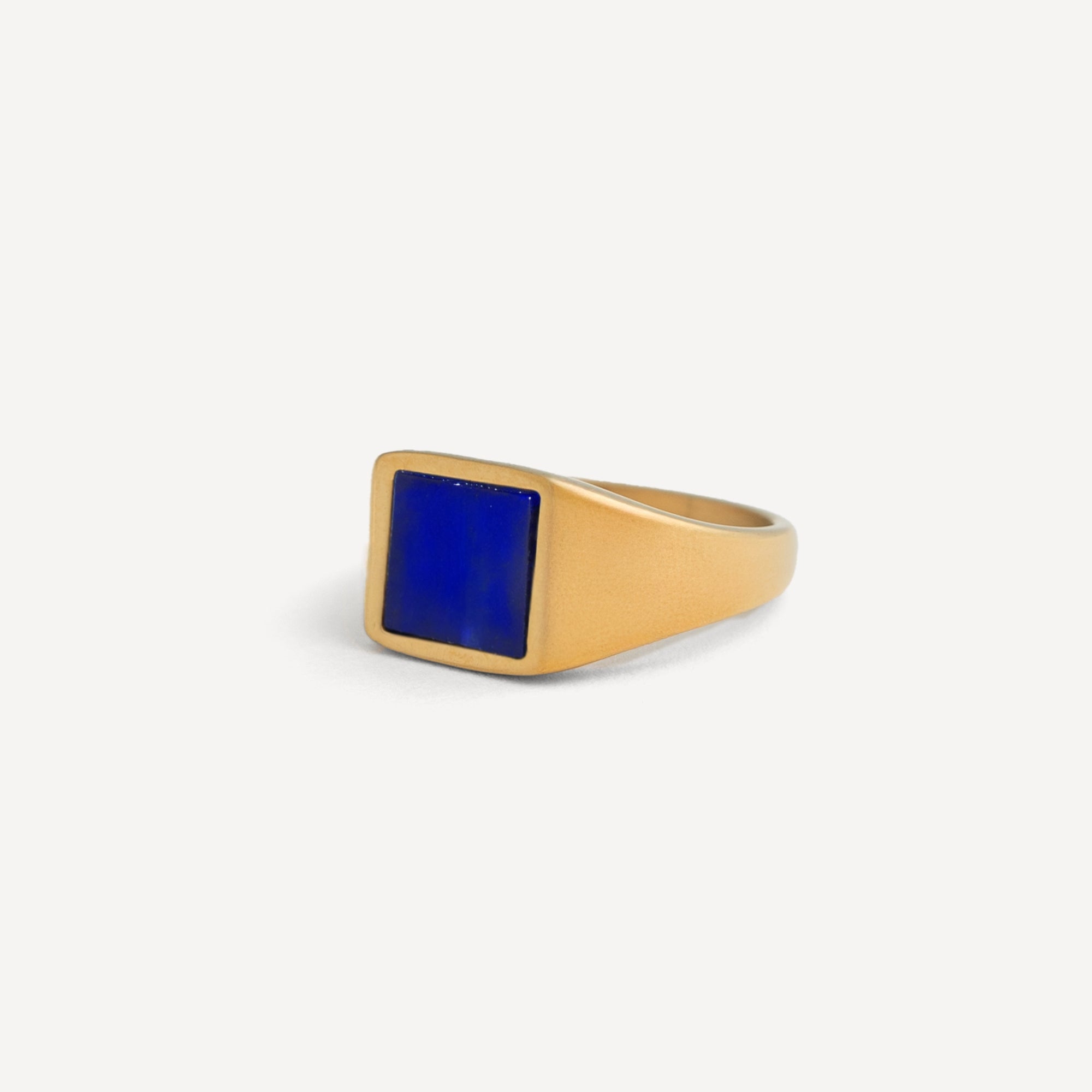 Gold ring with a blue stone on a white background
