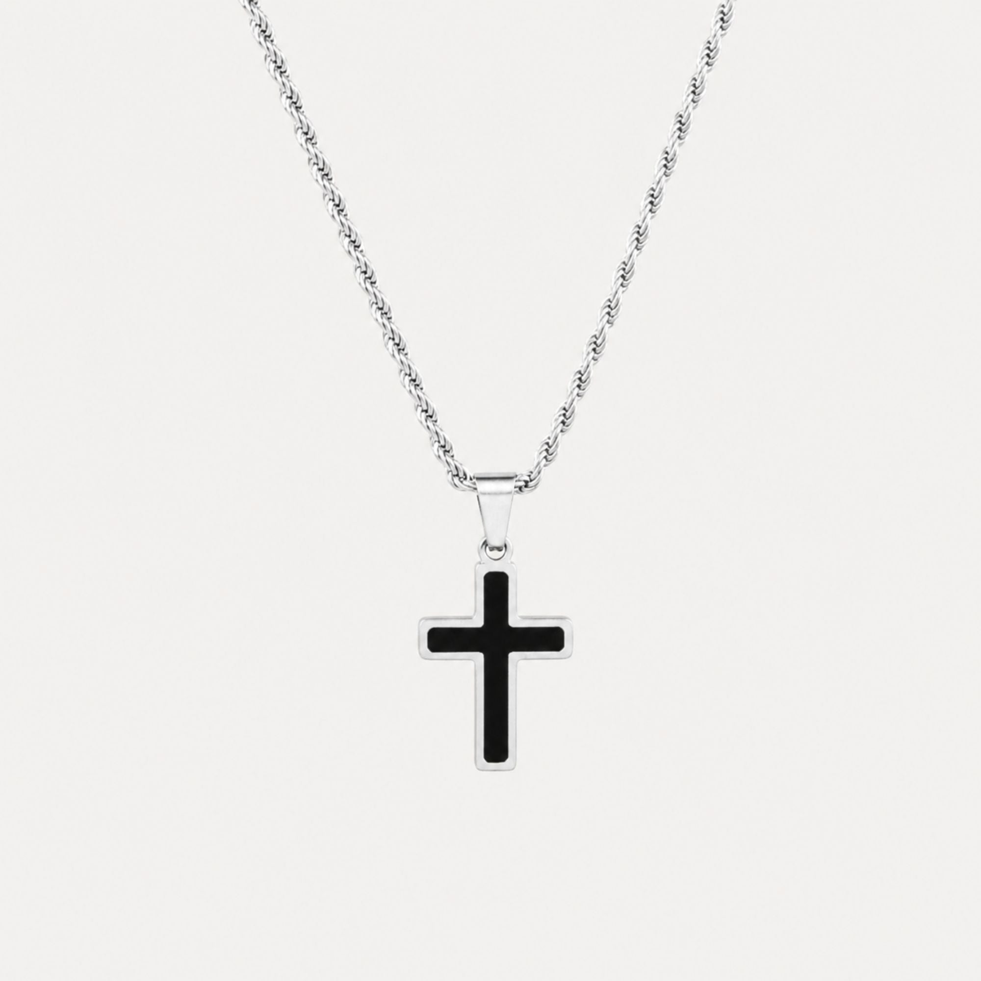 A silver chain necklace with a cross pendant featuring a black center and a silver border, displayed against a light gray background.