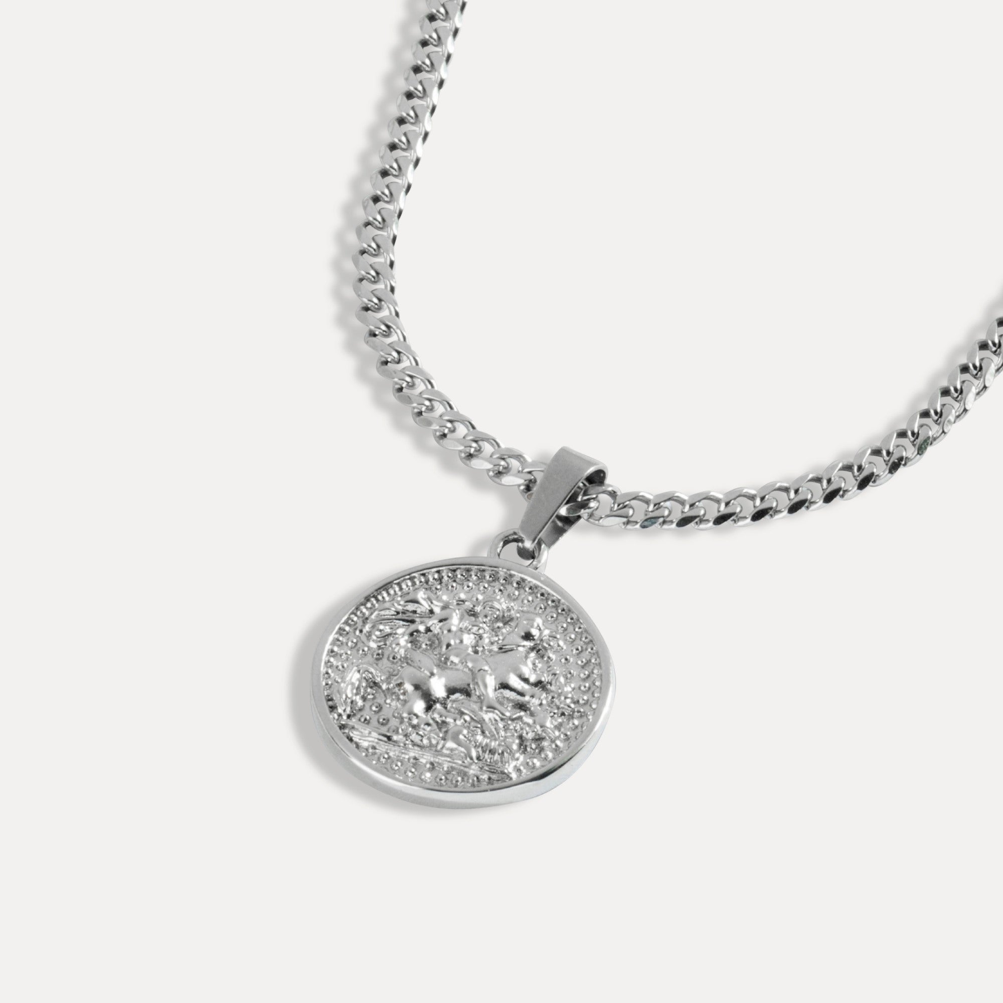 Silver necklace with a round pendant on a white background