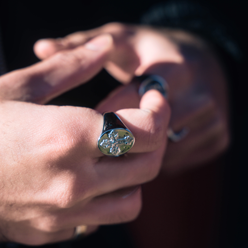 Close-up of a hand wearing a ring with a dark background