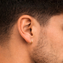 Close-up of an ear with a gold hoop earring