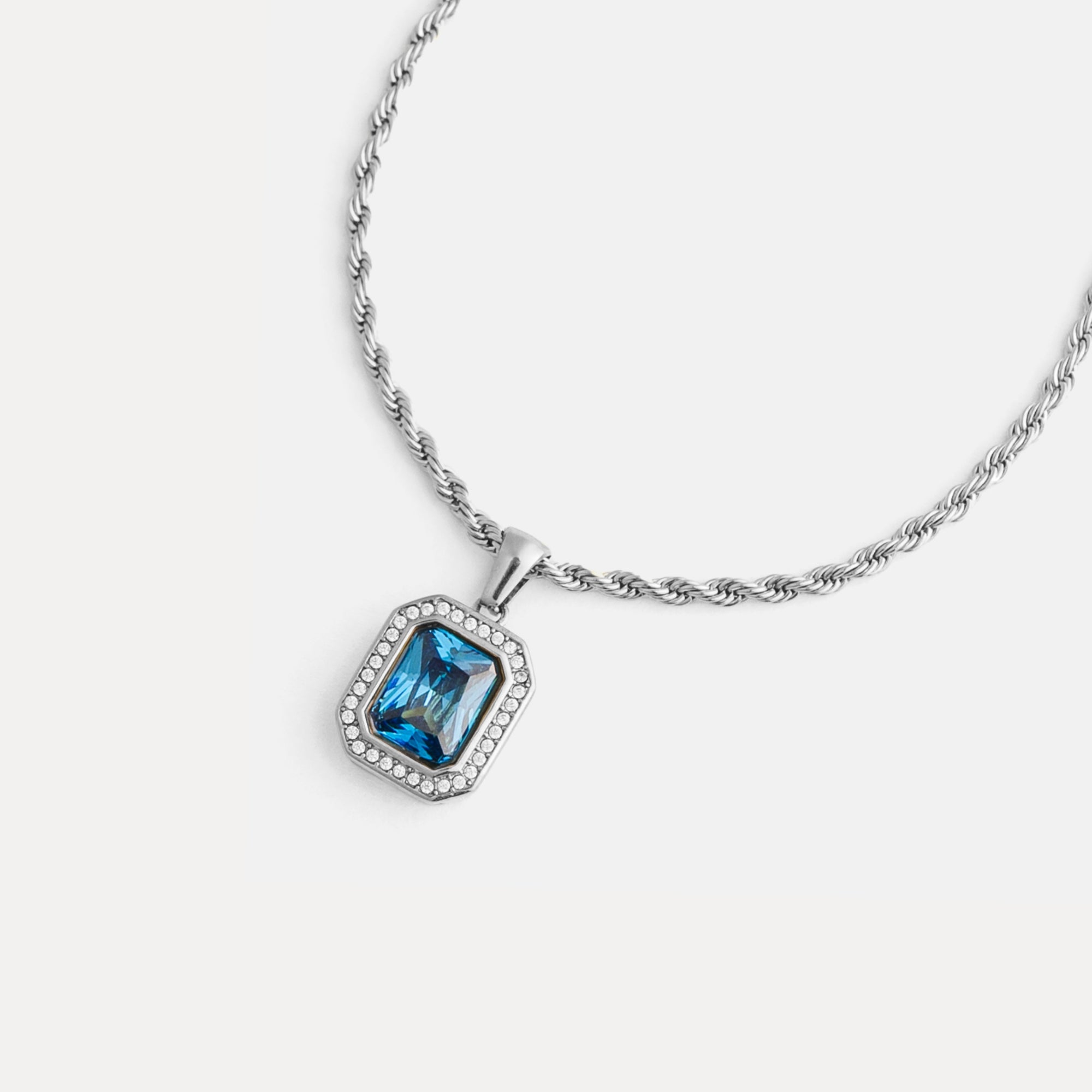Necklace with a blue gemstone pendant on a white background