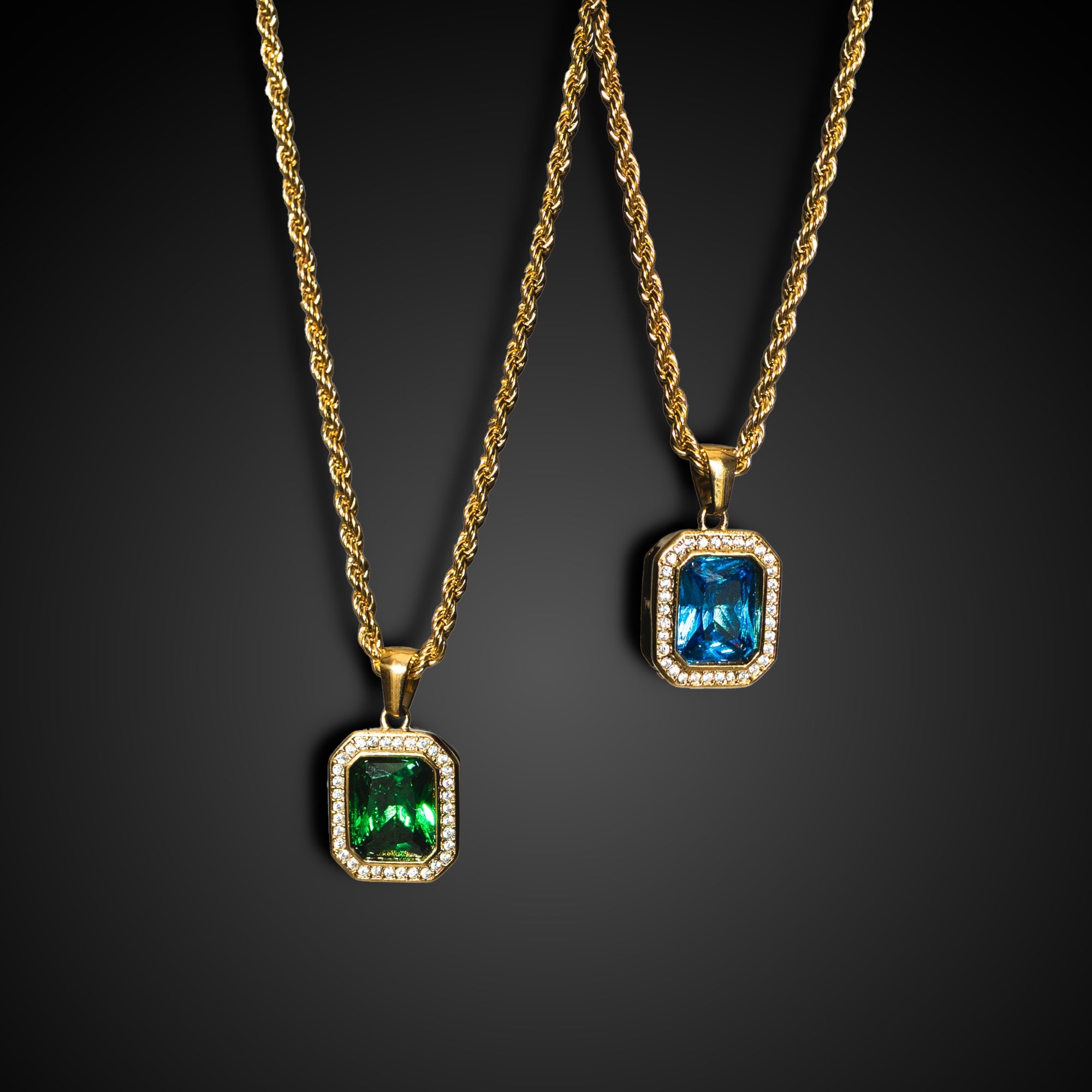 Two gold necklaces with gemstone pendants on a black background