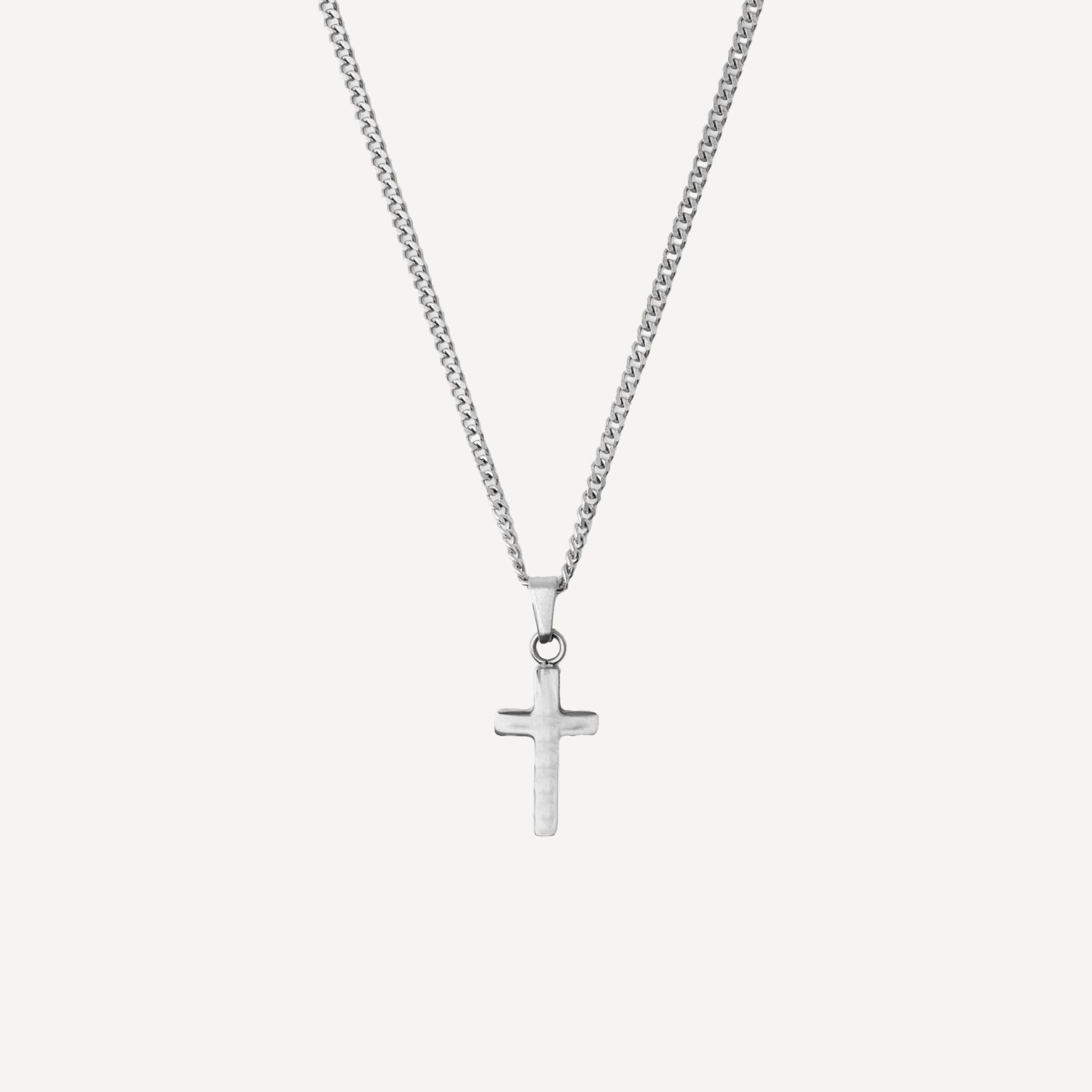 A silver cross pendant necklace on a silver chain, shown against a light gray background.