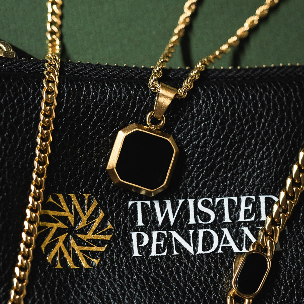 Gold necklace with a pendant on a black surface with 'Twisted Pendant' branding.