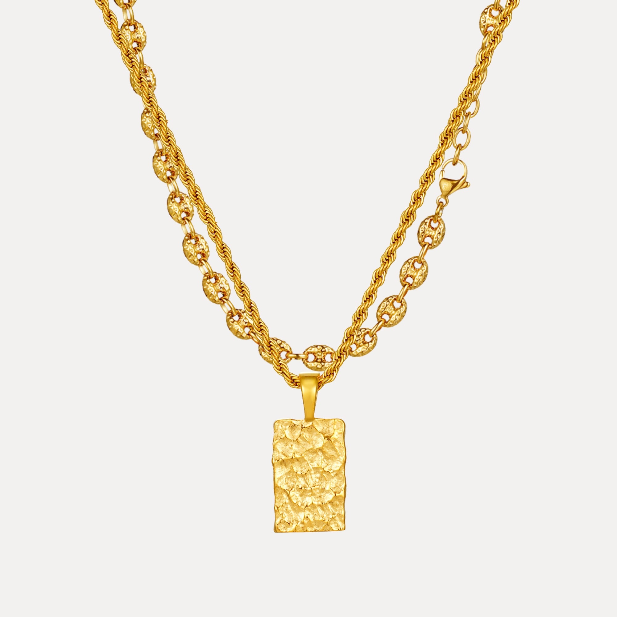 Gold necklace with a textured pendant on a white background