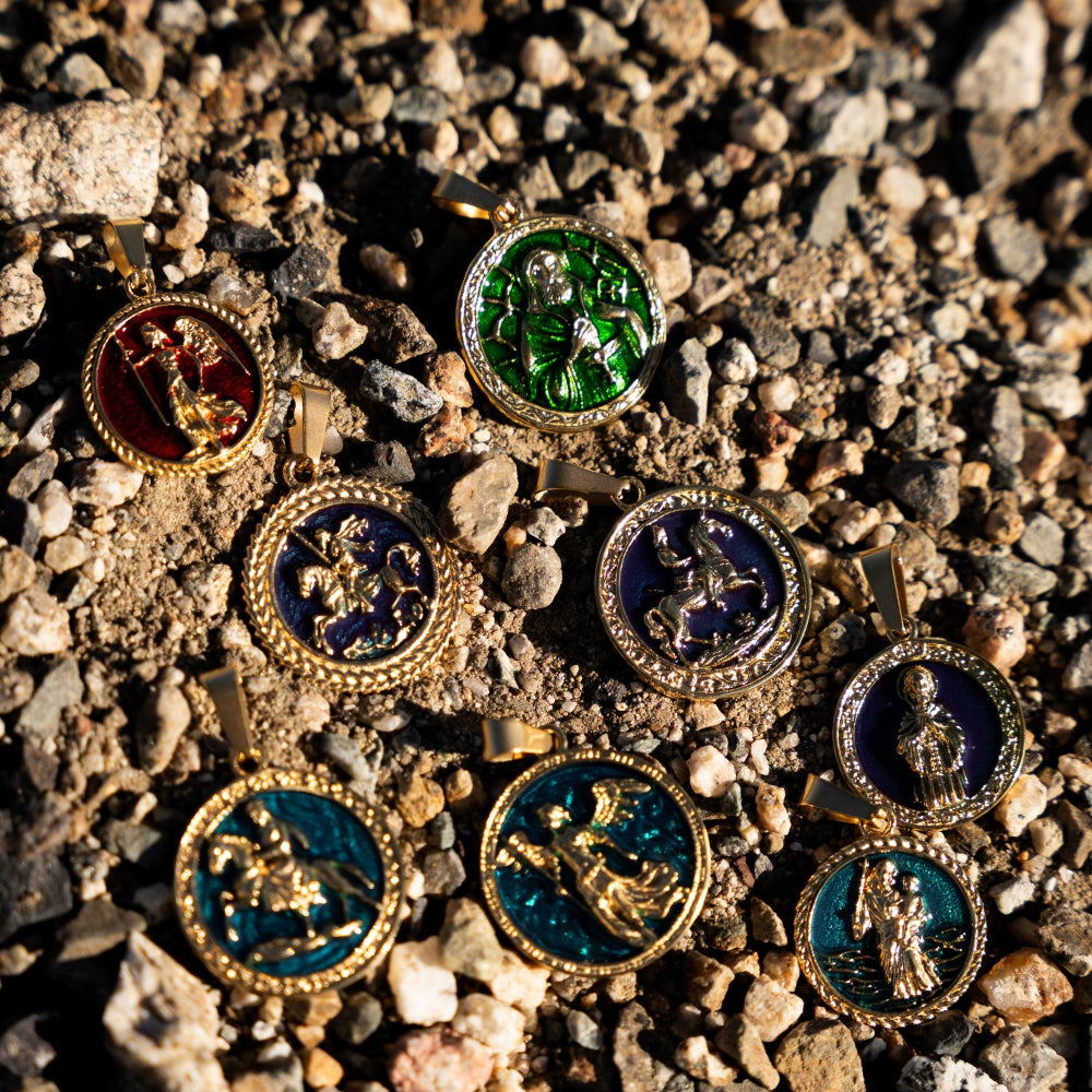 Decorative pendants with enameled designs on a gravel surface