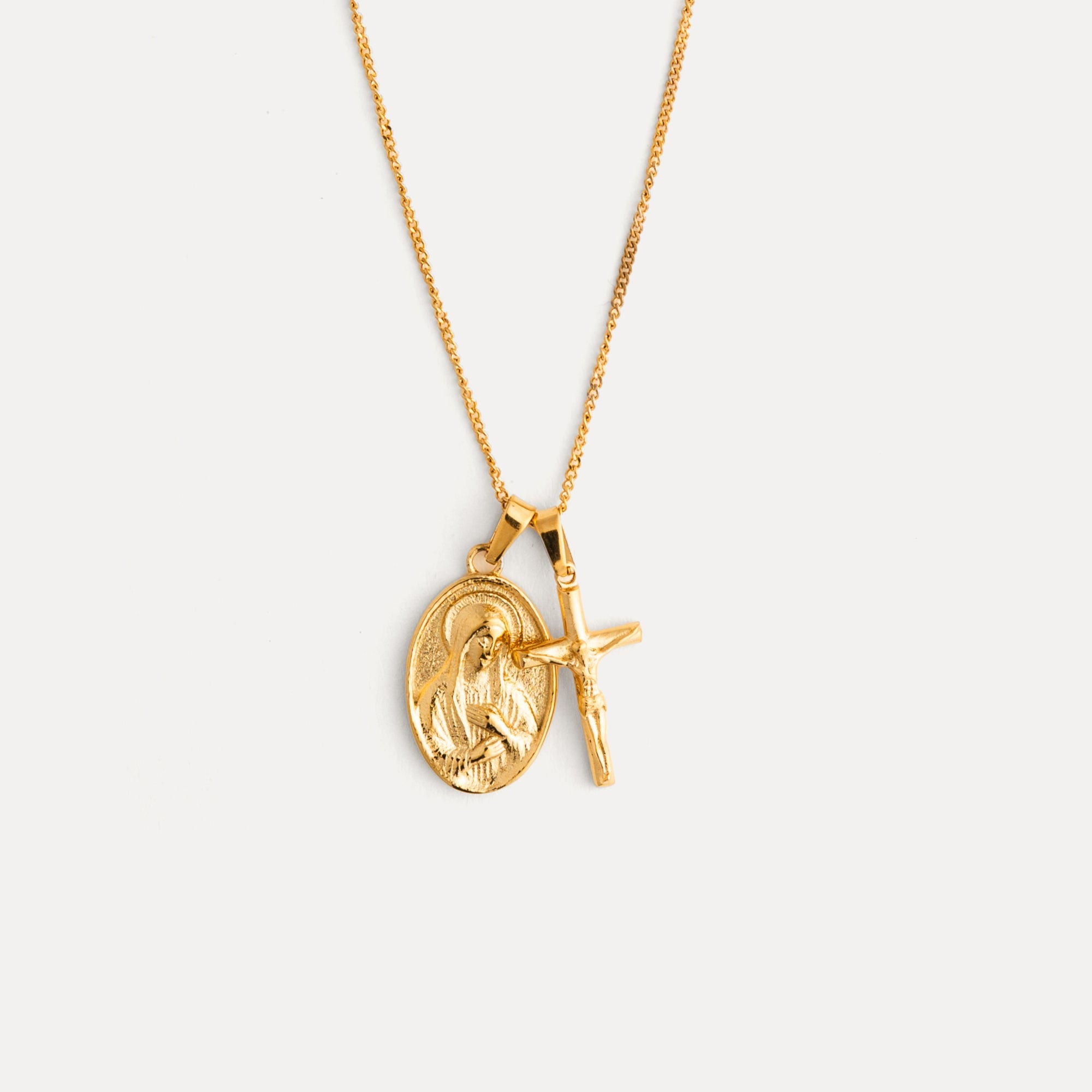 Gold necklace with two pendants on a light gray background