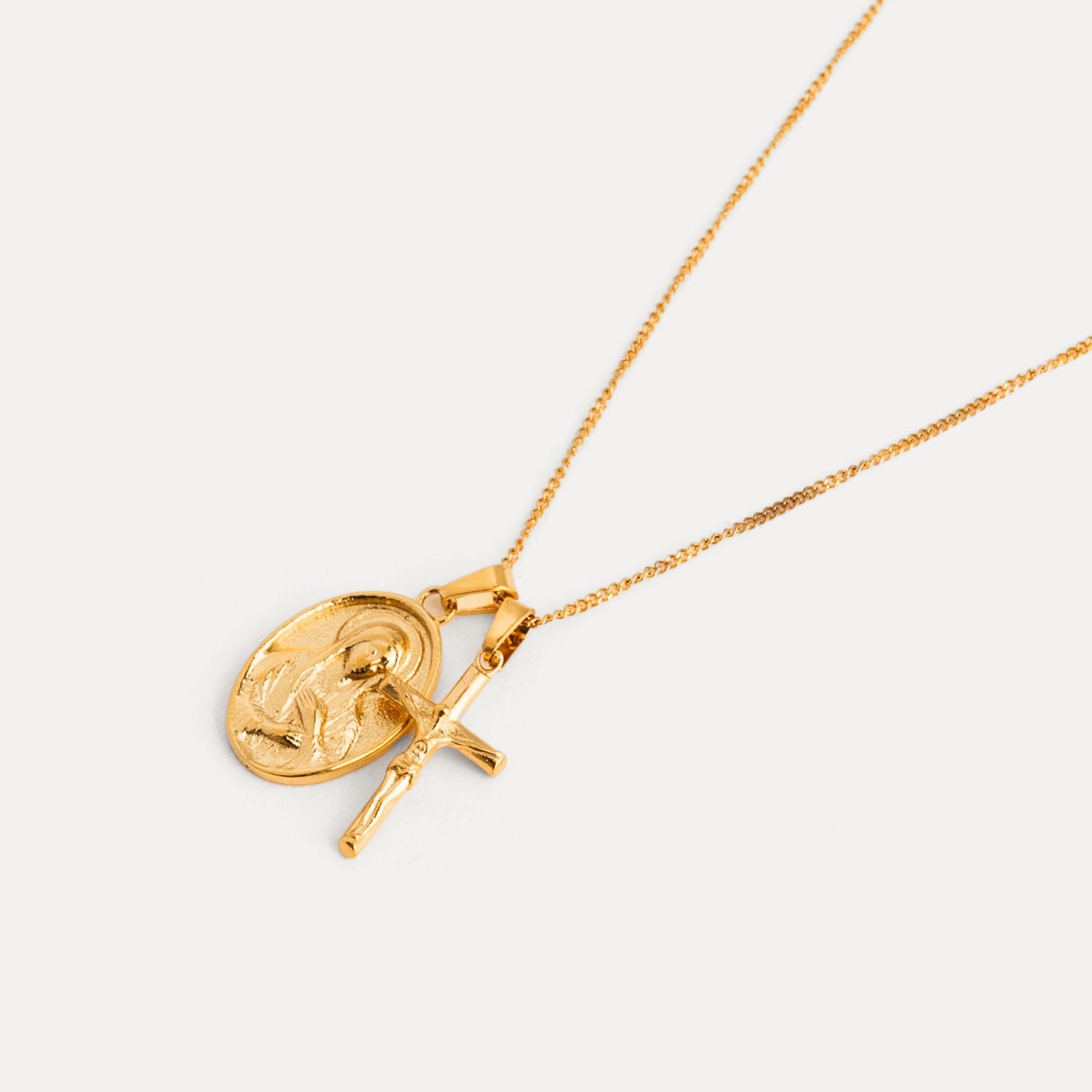 Gold necklace with a pendant on a light gray background