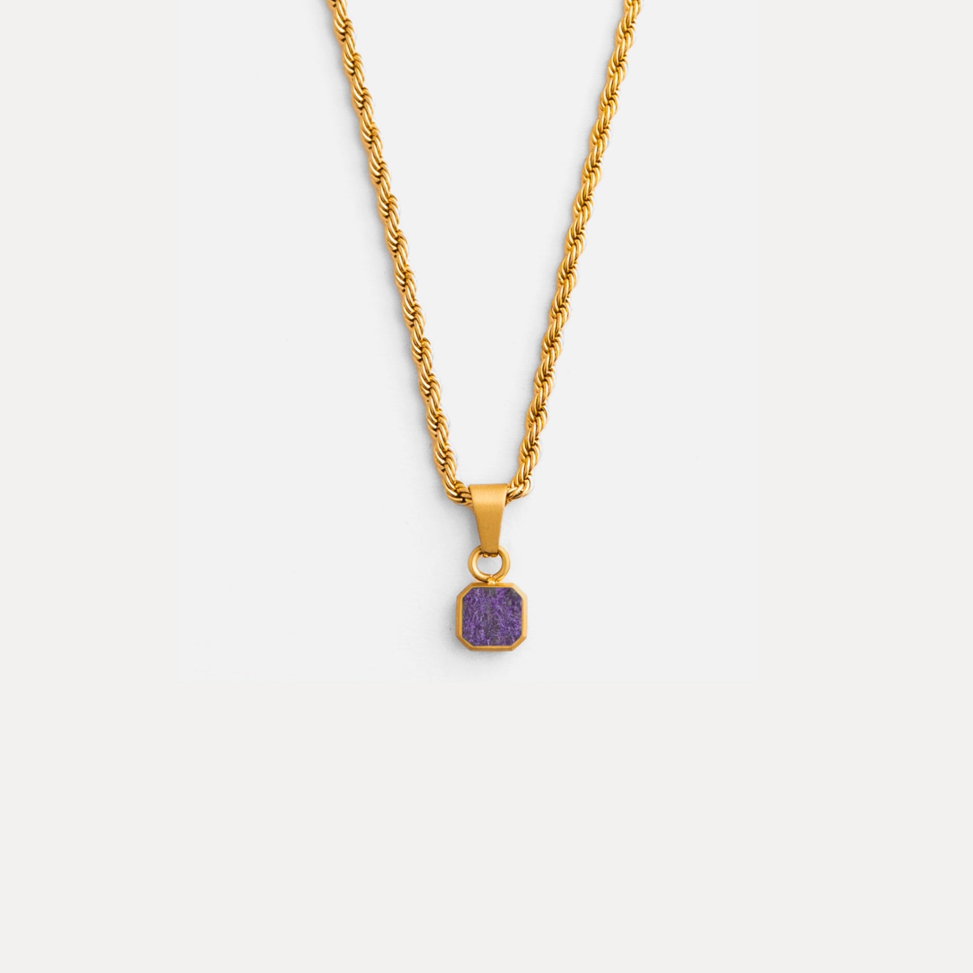 Gold necklace with a purple pendant on a white background