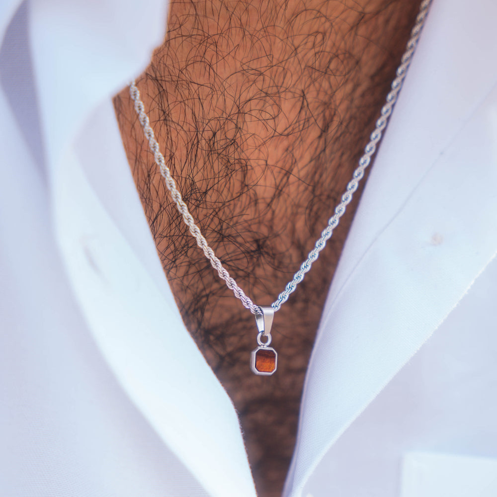 Silver necklace with a pendant on a mannequin with a white shirt and brown hair.