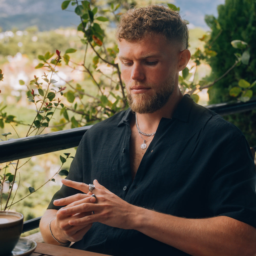 Man sitting outdoors with a scenic background