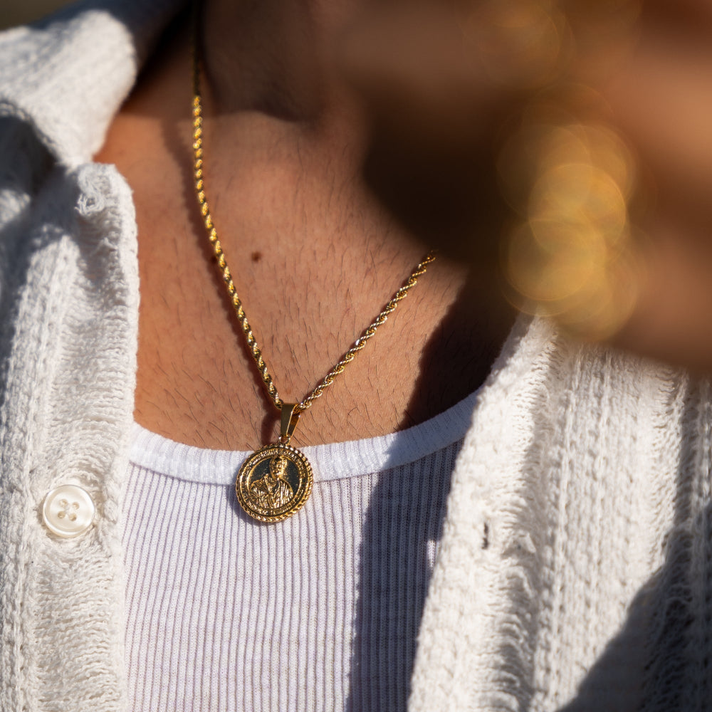 Gold necklace with a pendant worn by a person, blurred background