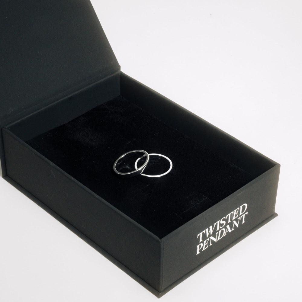 Two silver rings in a black box with 'Twisted Pendant' branding.
