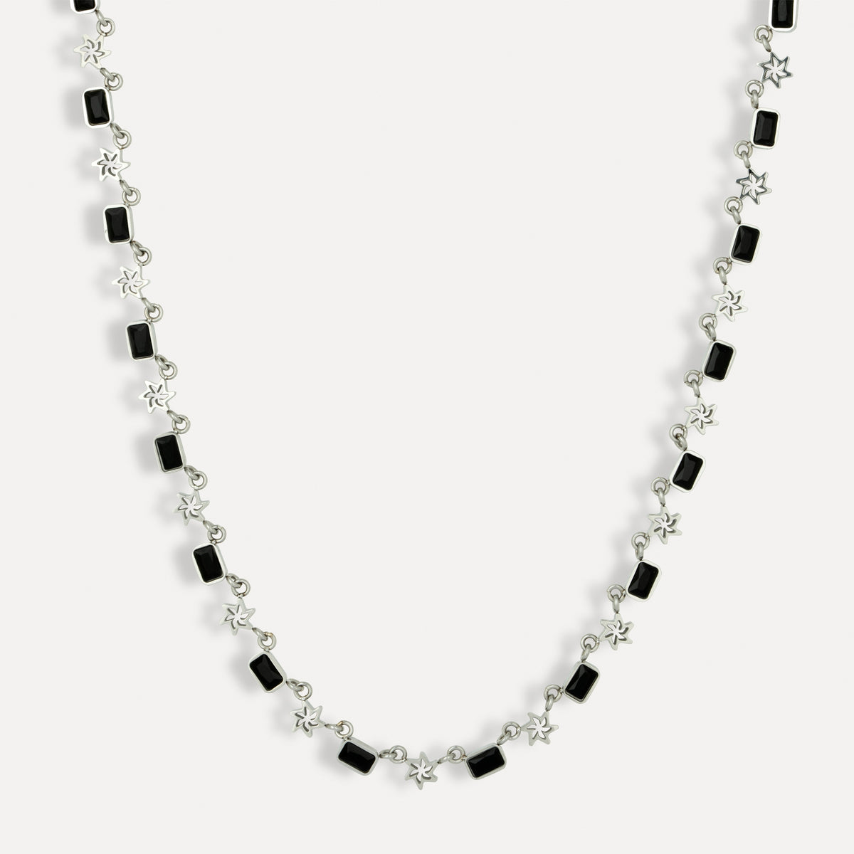 Necklace with black square beads and silver chain on a white background