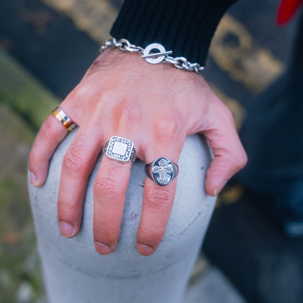 Hand with multiple rings on a blurred outdoor background
