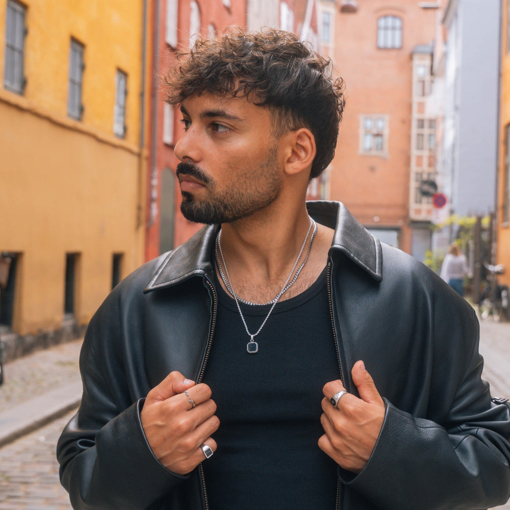 Man wearing a black leather jacket in an urban setting
