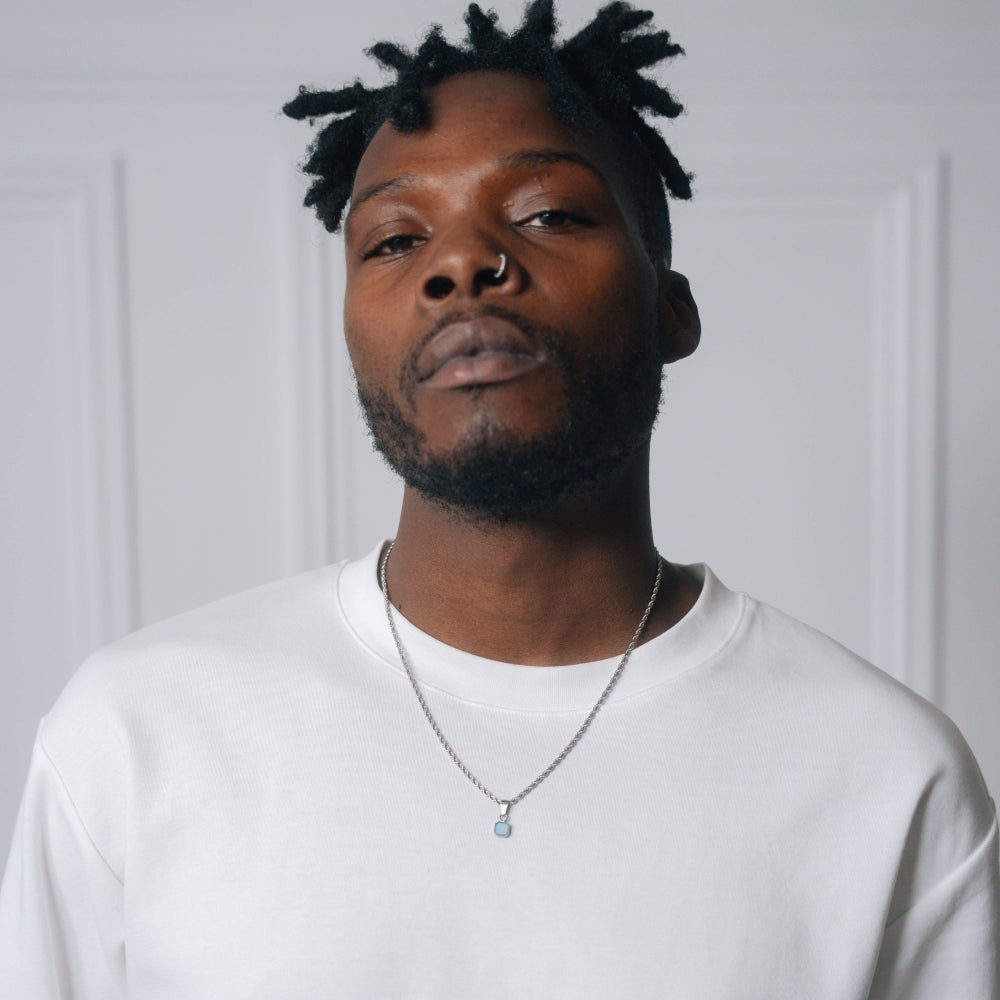 Man wearing a white shirt with a neutral background