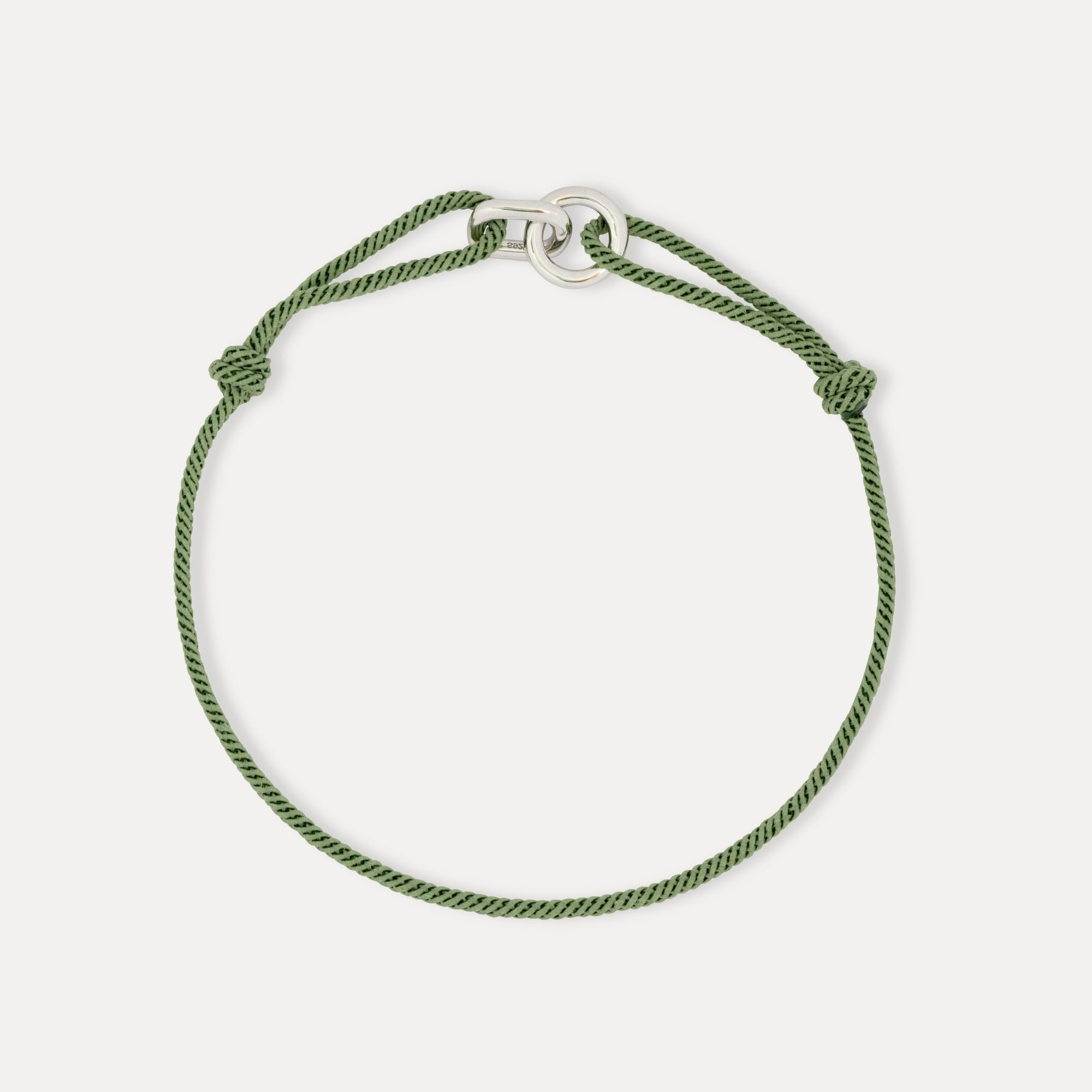 Green braided bracelet on a white background