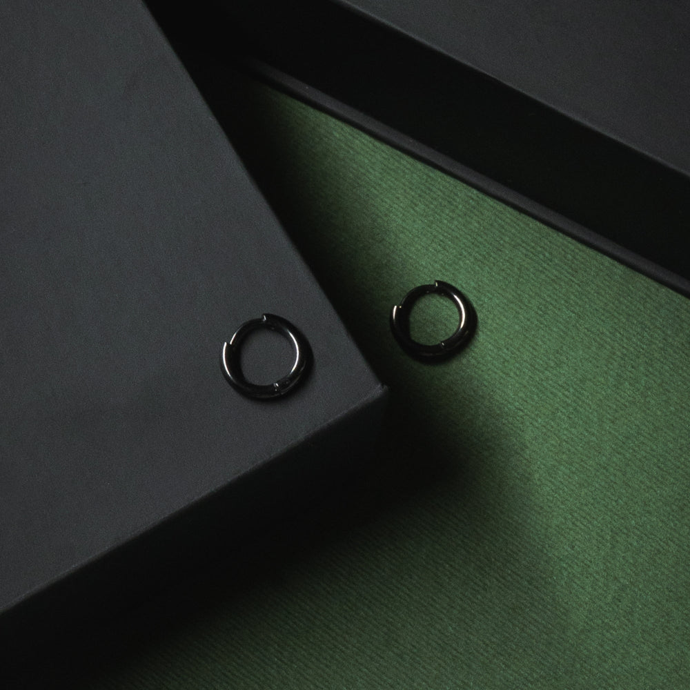 Two black rings on a green surface with a dark background