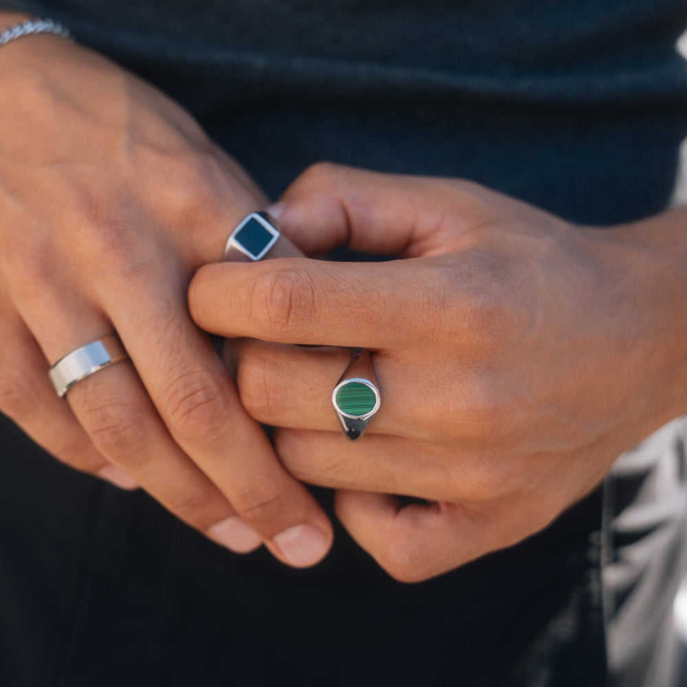 Close-up of hands with rings on fingers against a dark background