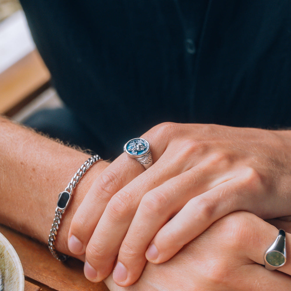 Close-up of hands with a ring and bracelet on a wooden surface