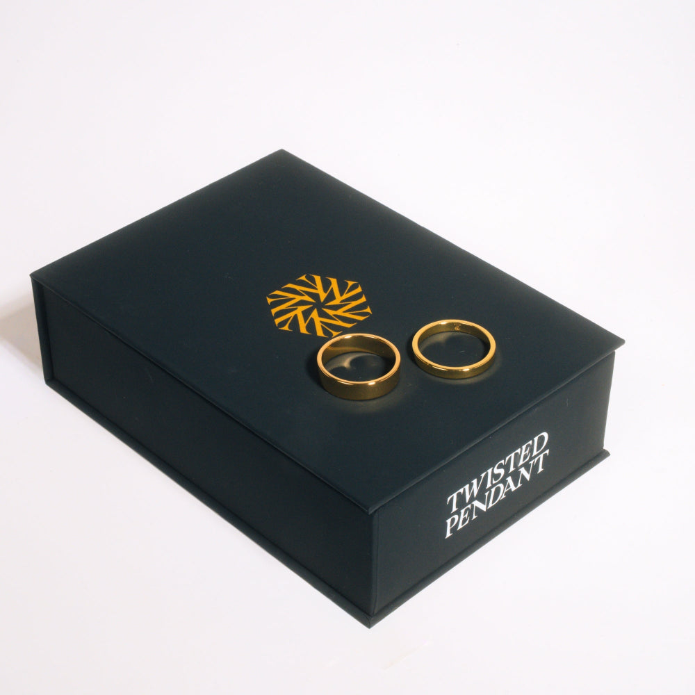 Black jewelry box with gold rings and 'Twisted Pendant' branding on a white background