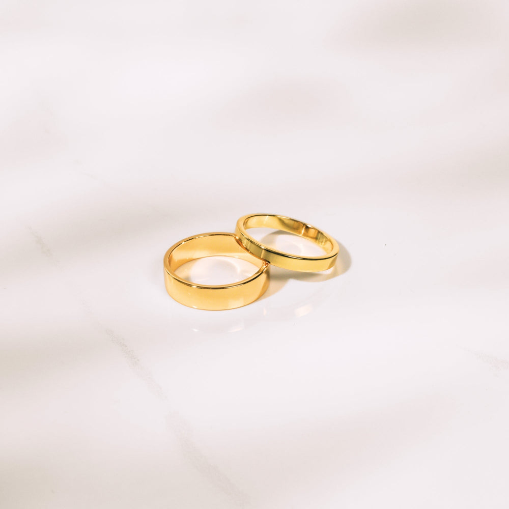 Two gold rings on a light beige background