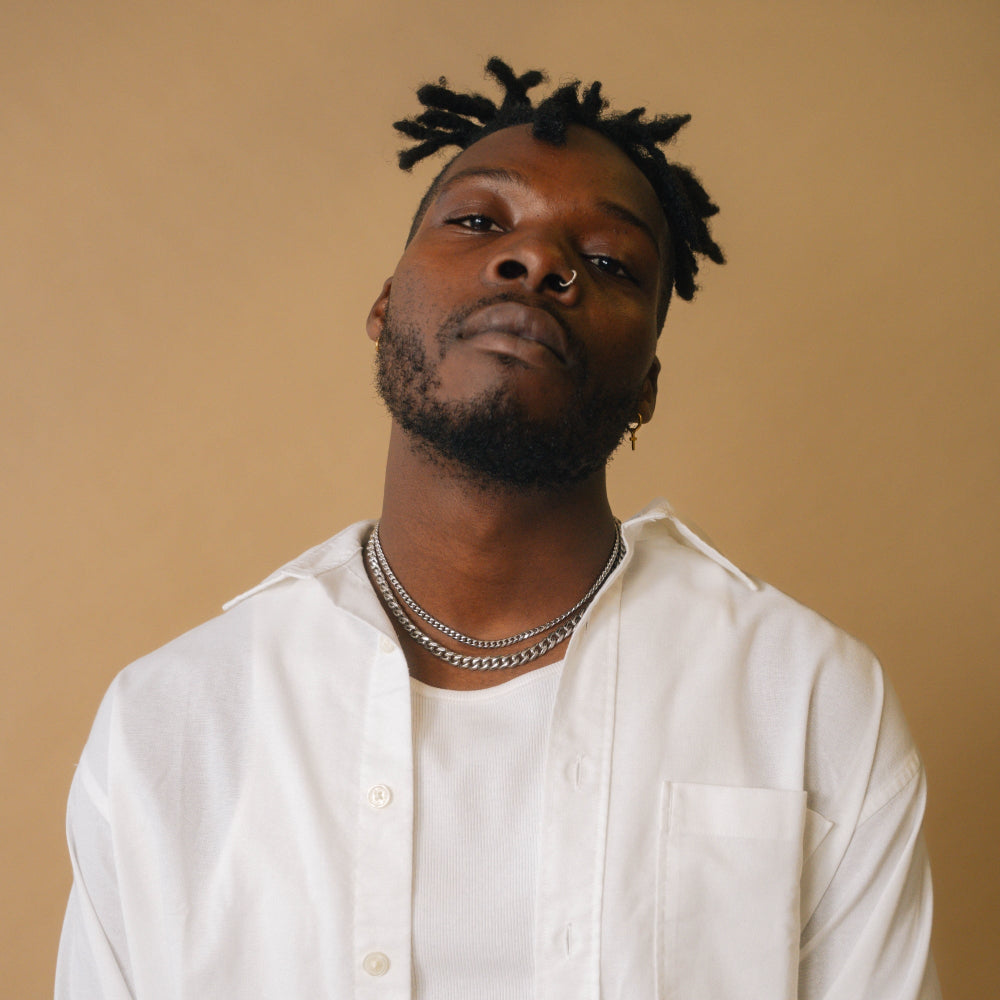 Man wearing a white shirt with a beige background