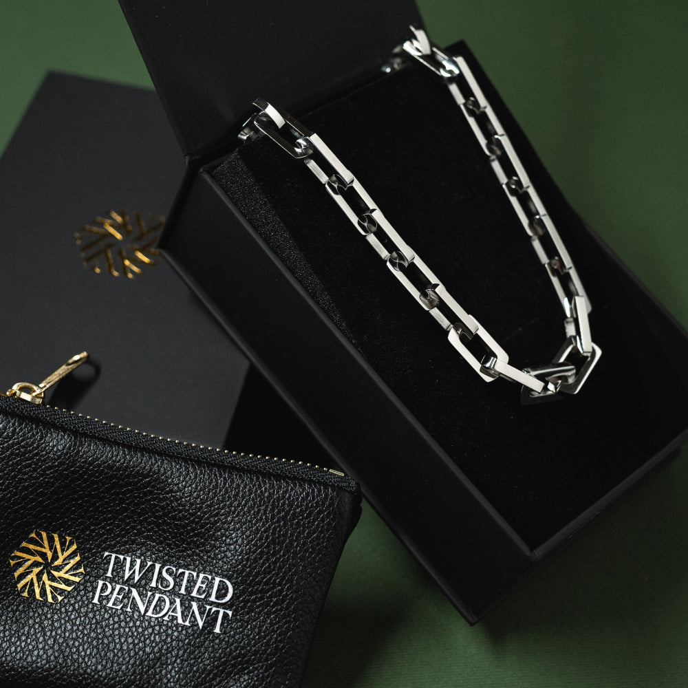 Silver chain necklace in a black box with 'Twisted Pendant' branding on a dark green background.