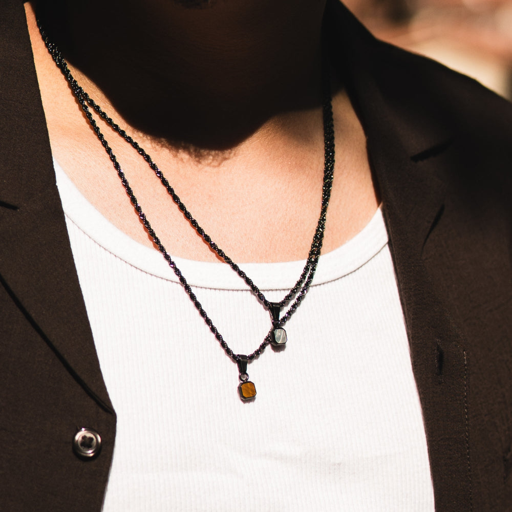 Necklace with beads worn by a person in a brown blazer and white shirt.