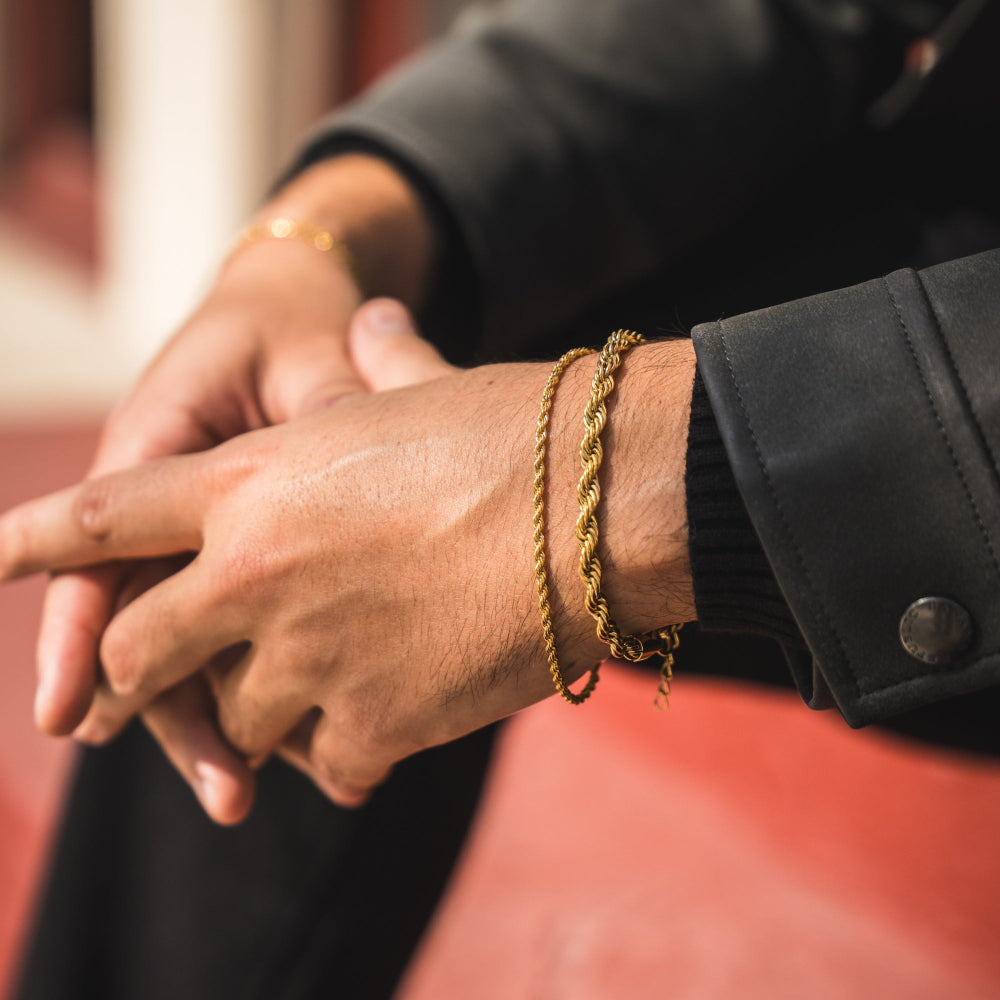 Close-up of hands with gold bracelets on a blurred background