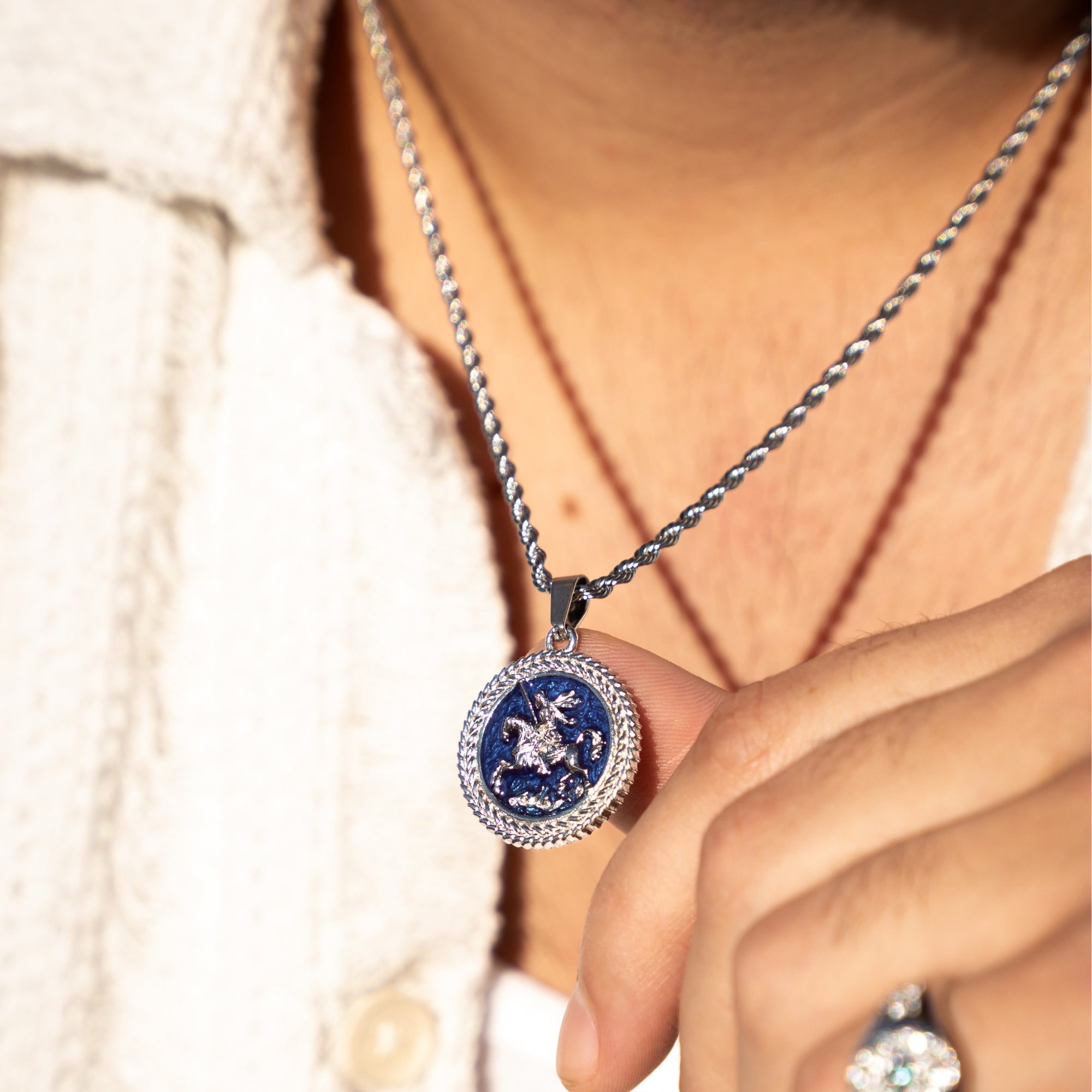 Close-up of a person wearing a necklace with a blue pendant.