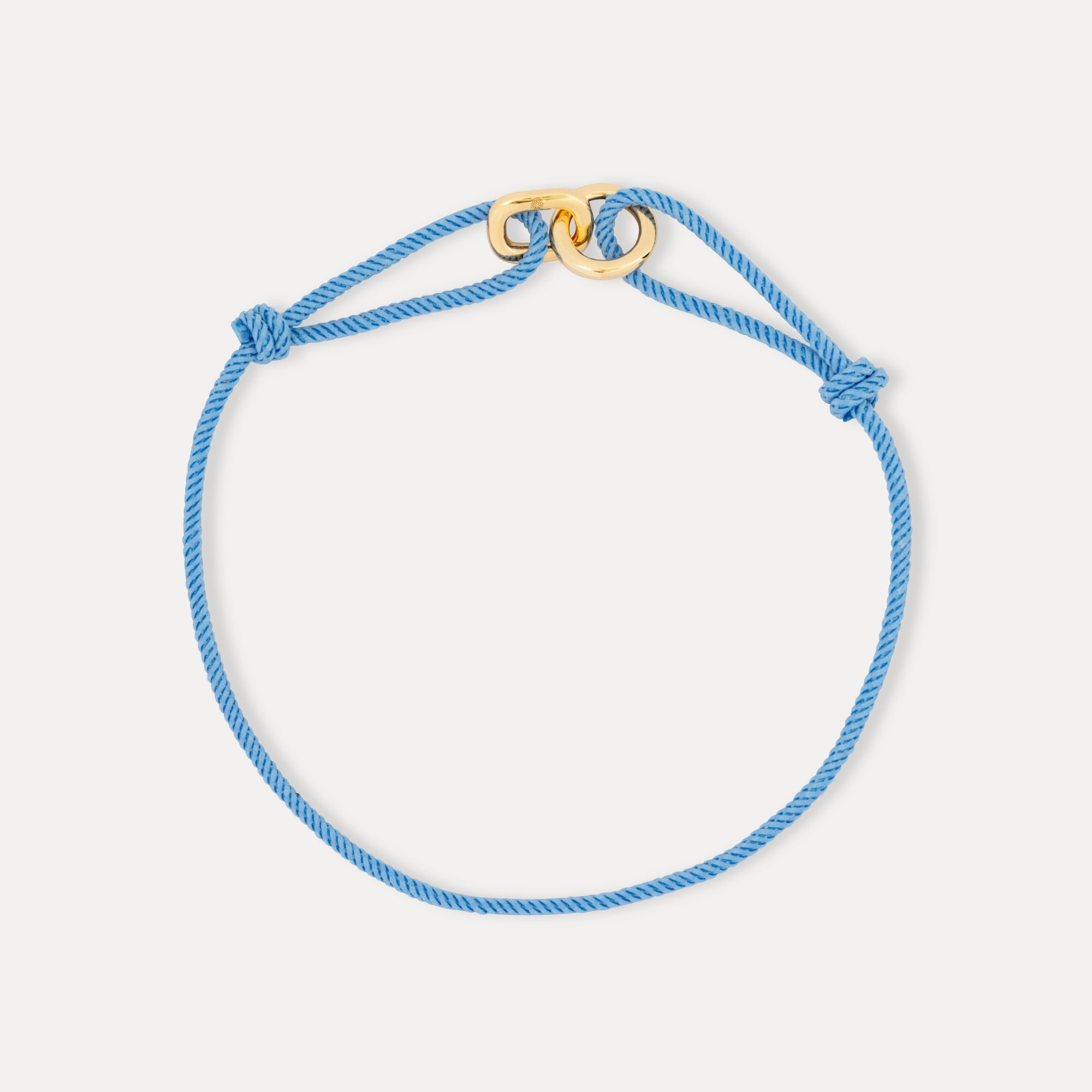 Blue braided bracelet with a gold clasp on a light gray background