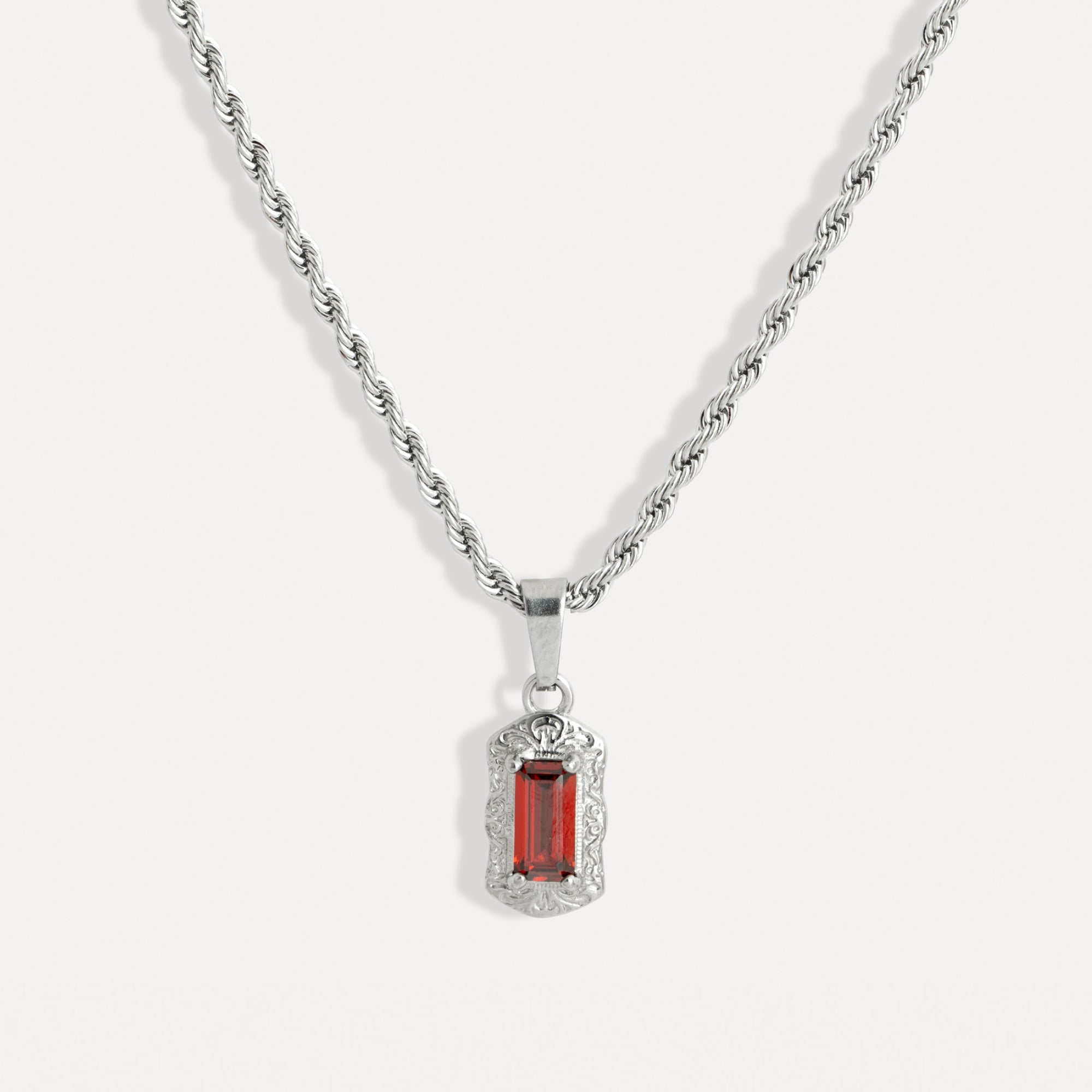 Silver necklace with a red gemstone pendant on a white background
