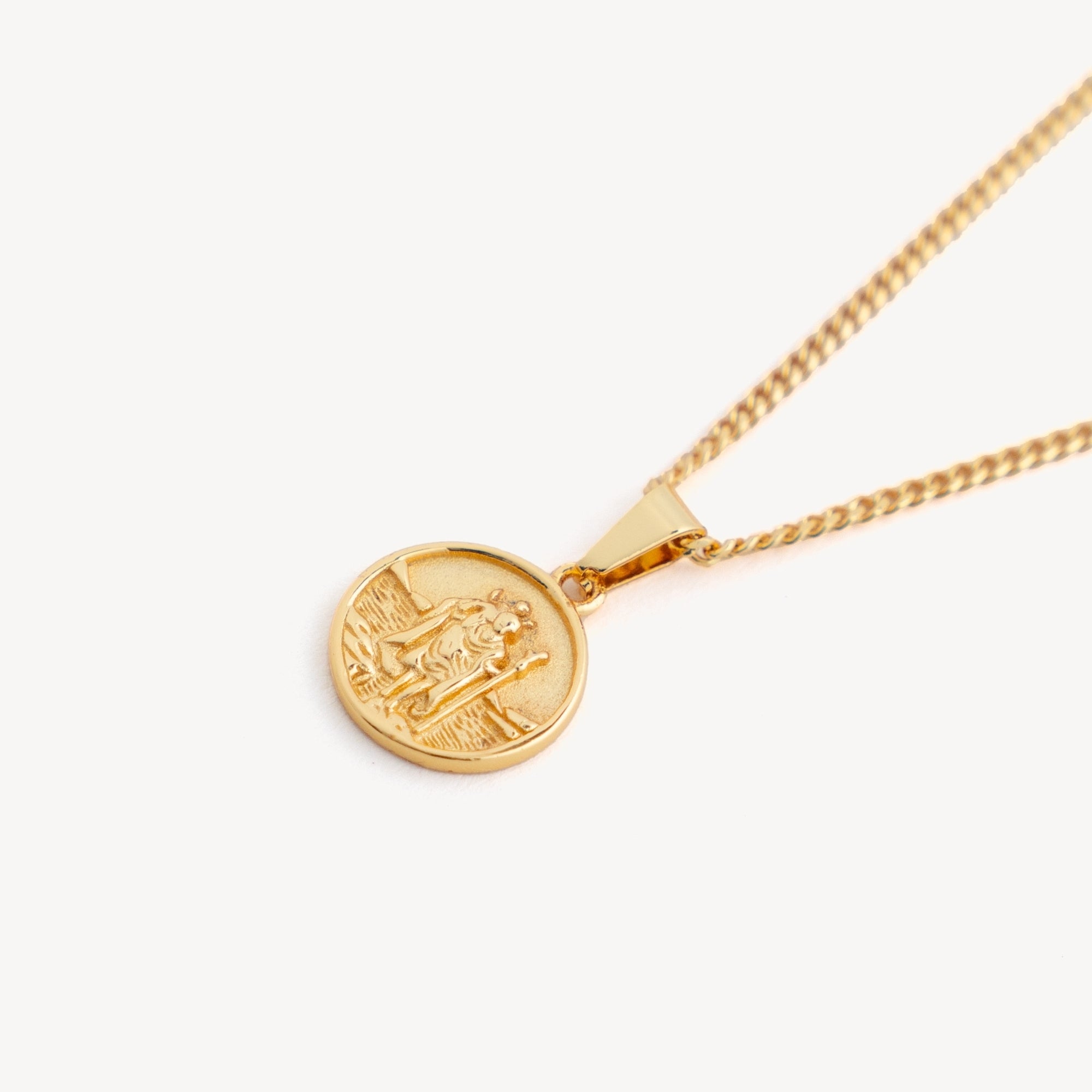 Gold necklace with a round pendant on a white background