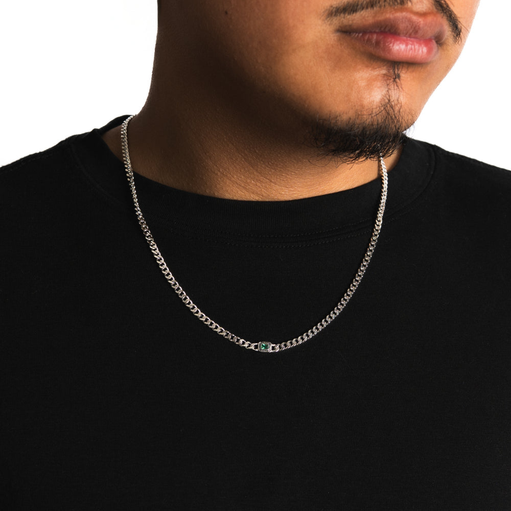 Man wearing a silver chain necklace on a black background