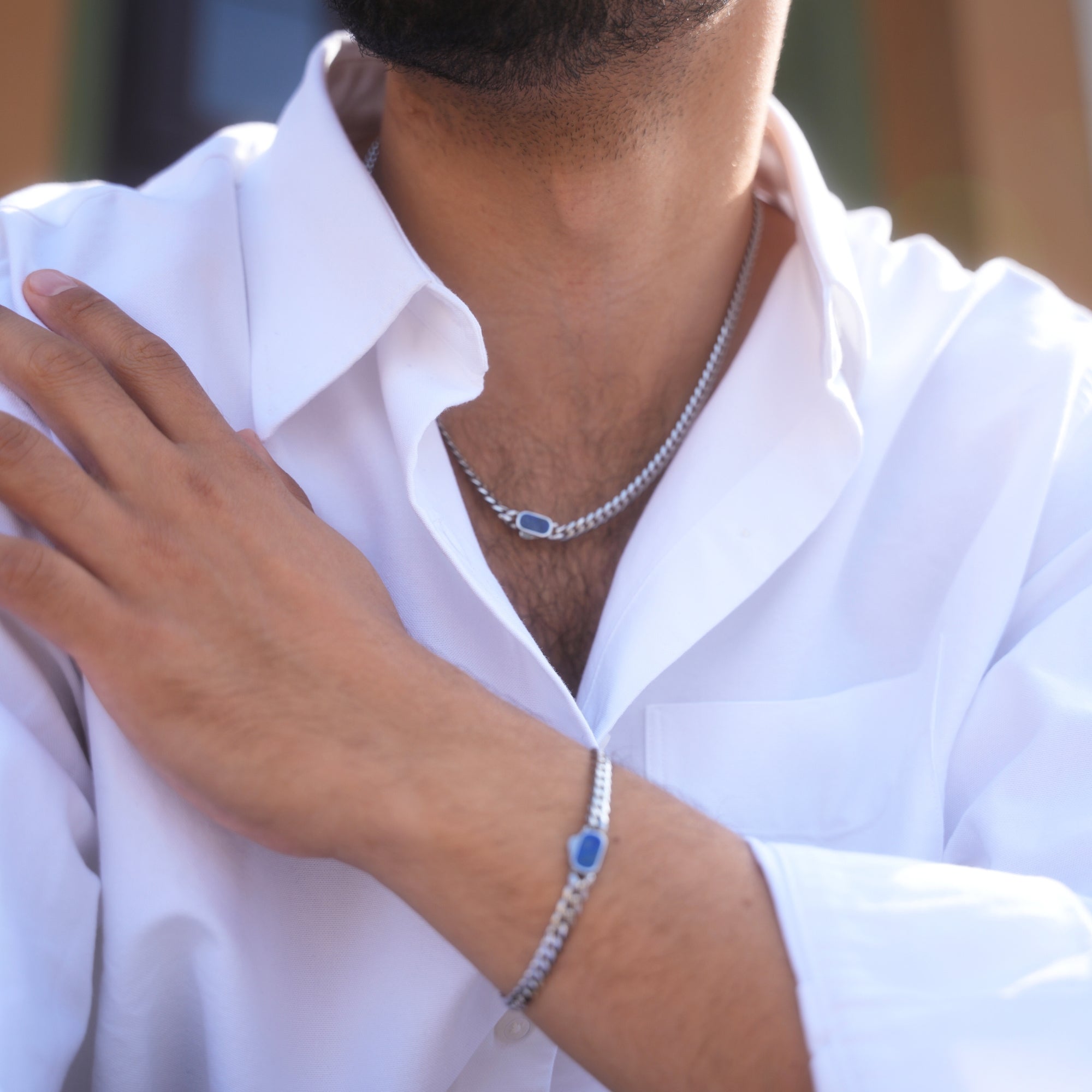 Person wearing a silver bracelet with blue stones on a blurred background