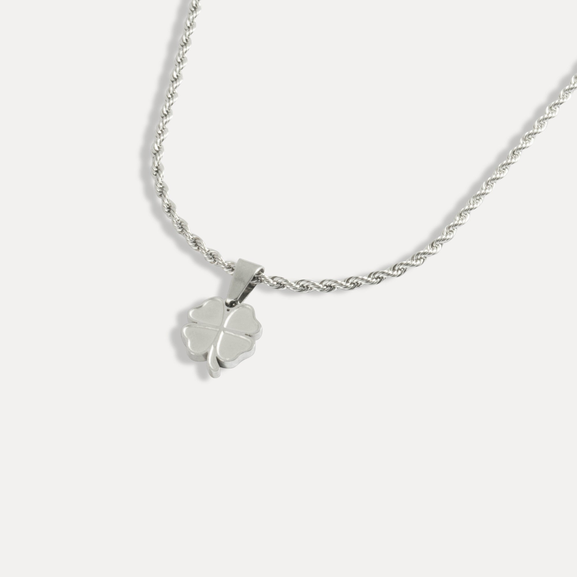Silver necklace with a clover pendant on a white background