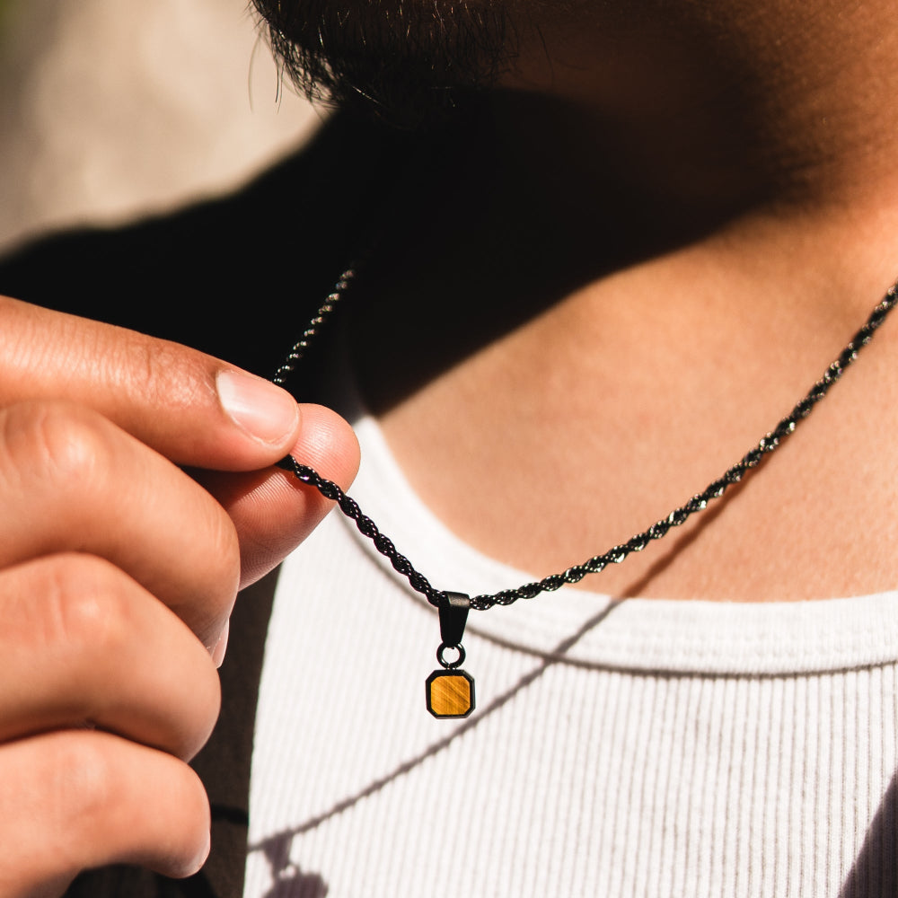 Person holding a necklace with a pendant
