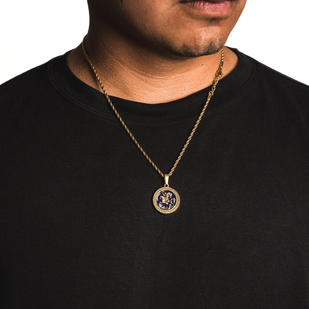 Man wearing a gold necklace with a pendant on a black shirt