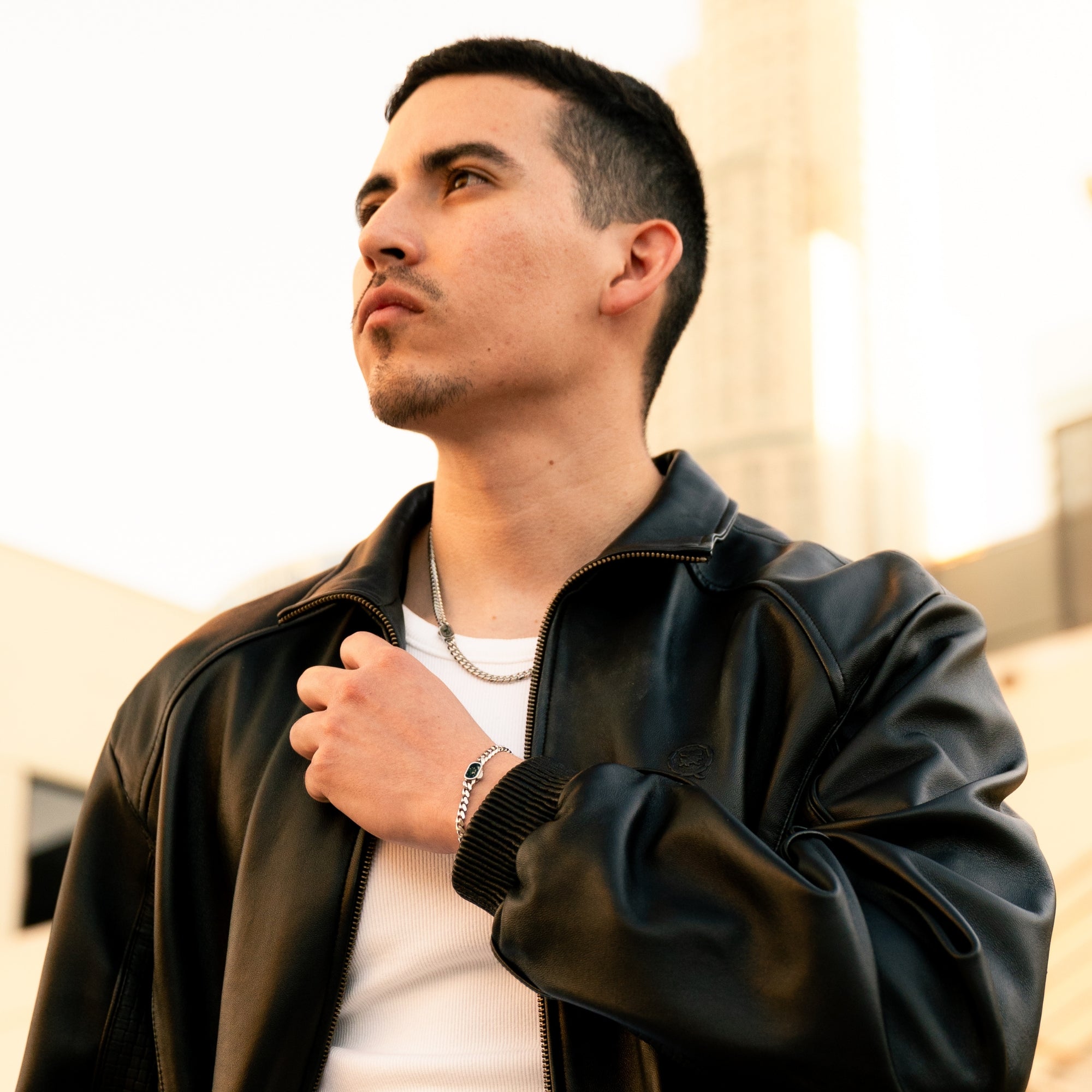 Man wearing a black leather jacket with a blurred background