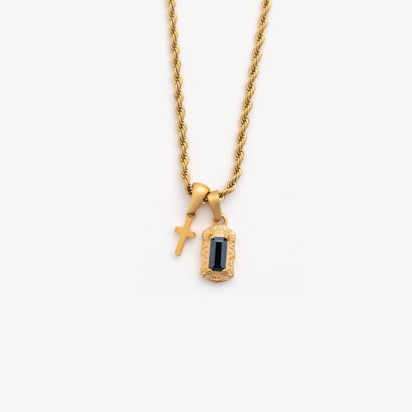 Gold necklace with two pendants on a white background