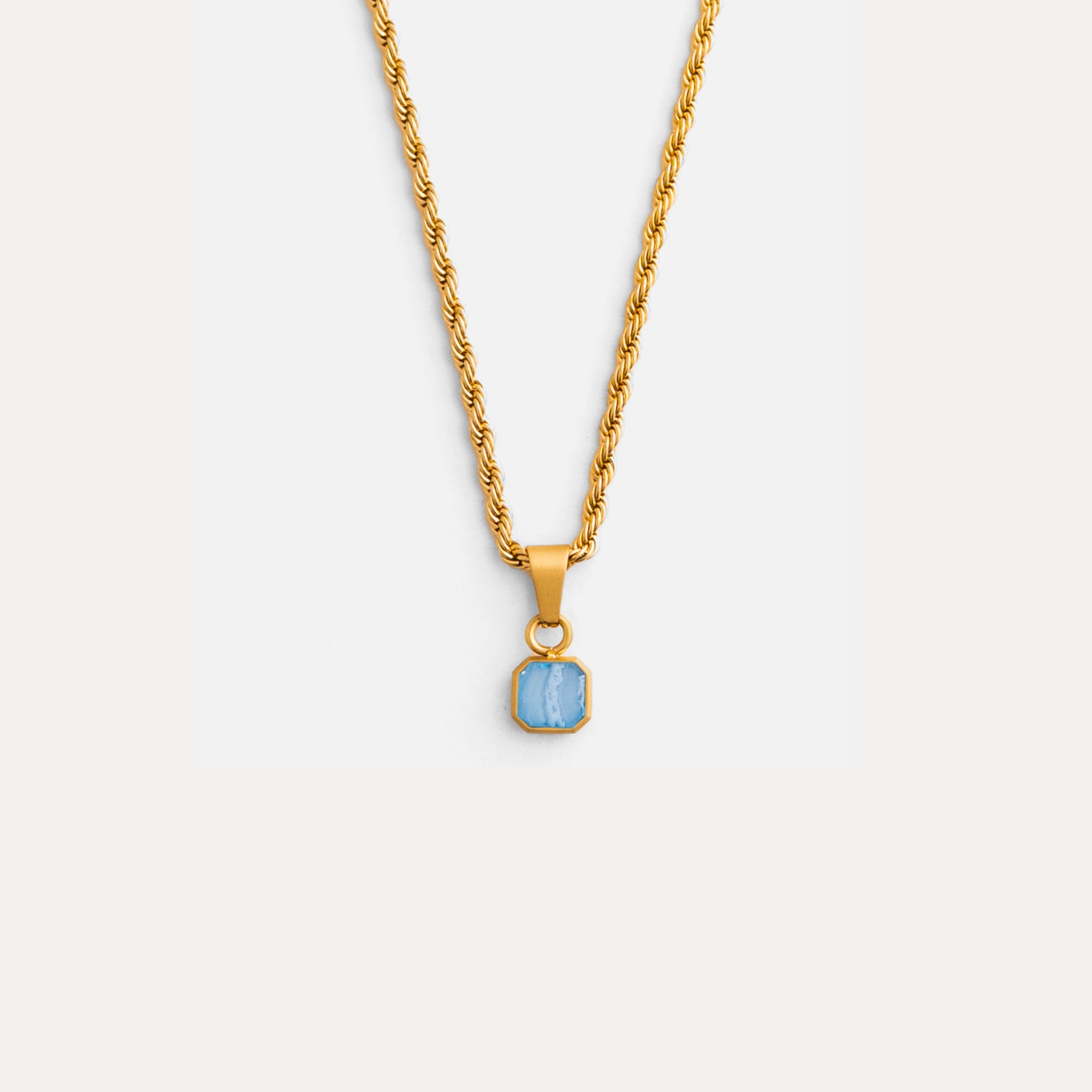 Gold necklace with a blue pendant on a white background