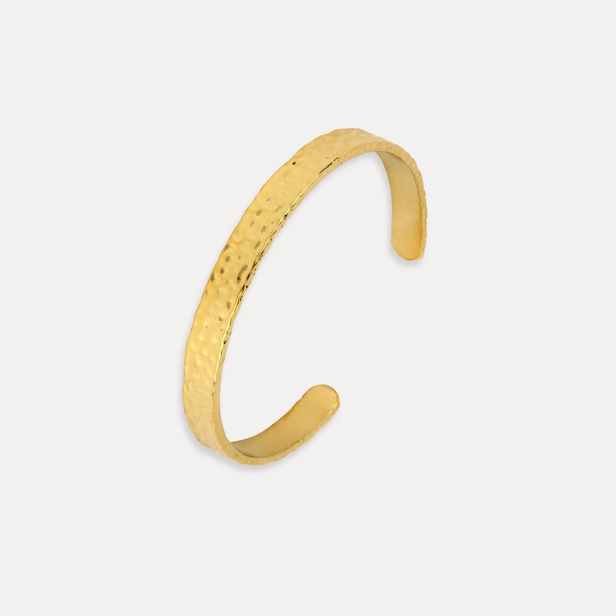 Gold bracelet on a light gray background